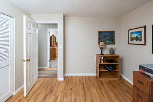 Hall featuring a textured ceiling and light wood-type flooring