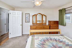 Carpeted bedroom featuring ceiling fan