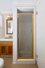 Bathroom featuring walk in shower, tile patterned floors, vanity, and toilet