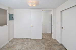 Interior space with electric panel and a textured ceiling