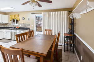 Tiled dining room with sink and ceiling fan