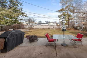 View of patio with grilling area and an outdoor fire pit