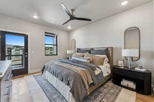 Bedroom with access to exterior, ceiling fan, and light hardwood / wood-style flooring