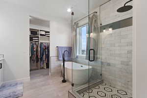 Bathroom with tile patterned floors, independent shower and bath, and tile walls