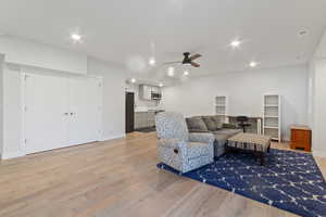 Living room with light hardwood / wood-style floors and ceiling fan