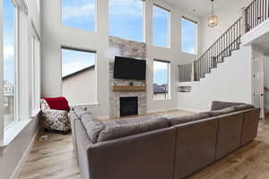 Living room with a fireplace, a chandelier, and light hardwood / wood-style flooring