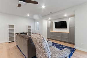 Living room with ceiling fan and light hardwood / wood-style flooring