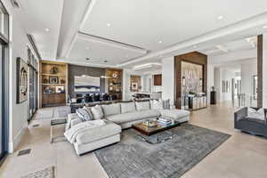 Tiled living room with built in features and a raised ceiling