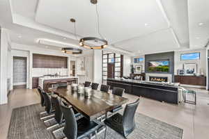 Dining room with light tile patterned floors and a tray ceiling