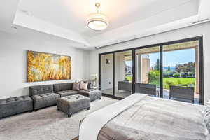 Bedroom with access to outside and a raised ceiling