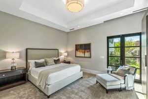 Carpeted bedroom featuring a raised ceiling