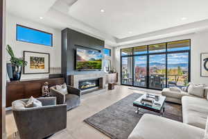 Living room with light tile patterned floors and a tray ceiling