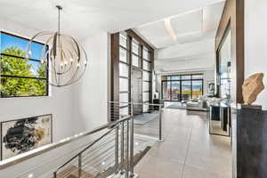 Hall featuring a chandelier and light tile patterned flooring