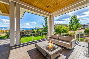 Deck with a mountain view and an outdoor living space with a fire pit