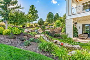 View of yard with a balcony and a patio