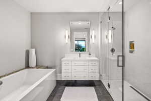 Bathroom featuring tile patterned floors, vanity, and separate shower and tub