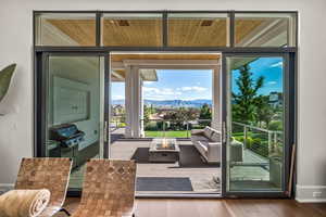 Doorway to outside with a mountain view, hardwood / wood-style flooring, and expansive windows