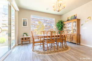 Dining space with plenty of natural light, a chandelier, and light wood-type flooring