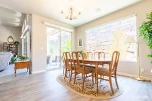 Dining room with wood-type flooring and a chandelier