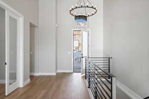 Foyer entrance featuring a chandelier, hardwood / wood-style floors, and a high ceiling