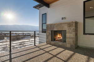 Covered patio featuring a mountain view and an outdoor stone fireplace