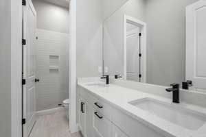 Basement Bathroom featuring tiled shower, vanity