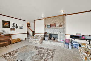 Living room with crown molding, a brick fireplace, and light colored carpet