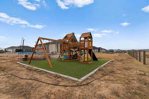 View of playground featuring a yard and a trampoline