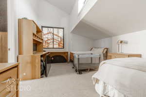 Carpeted bedroom featuring lofted ceiling