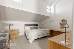 Carpeted bedroom with lofted ceiling