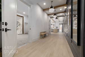 Hall featuring light hardwood / wood-style floors and beamed ceiling