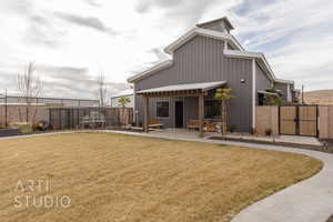 Rear view of house with a yard and a patio area