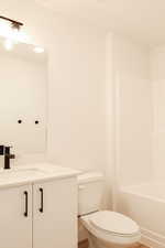 Bathroom featuring vanity, hardwood / wood-style floors, and toilet