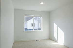 Unfurnished room featuring light colored carpet