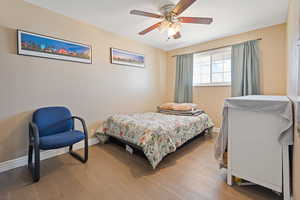 Bedroom with baseboards, ceiling fan, and light wood finished floors