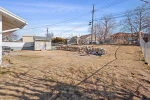 View of yard featuring an outbuilding and fence