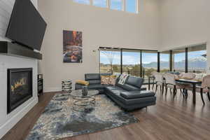 Living room with a towering ceiling, cozy  fireplace, and outstanding city and mountain views.