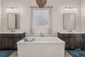 Primary en suite bathroom with dual vanities and a spacious soaking tub.