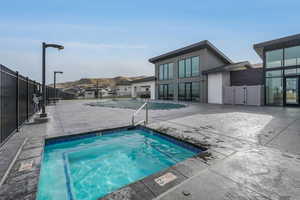 Clubhouse hot tub and swimming pool featuring a mountain view and a large patio area