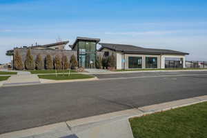 Community clubhouse featuring a spacious gathering area with ample seating, a TV, kitchen, pool, hot tub, gym, BBQ/picnic area, and plenty of green space surrounding the playground.