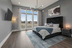 This primary bedroom is bathed in natural light, thanks to its large windows that offer sweeping views and create a serene, airy atmosphere.