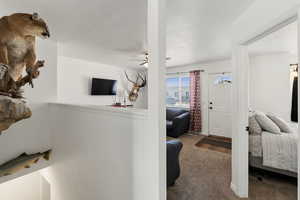 Bedroom featuring carpet, a textured ceiling, and ceiling fan