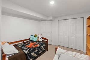 Bedroom featuring light colored carpet and a closet