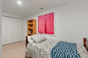 Carpeted bedroom featuring a closet