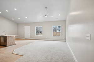 Living room with sink, light colored carpet, and ceiling fan