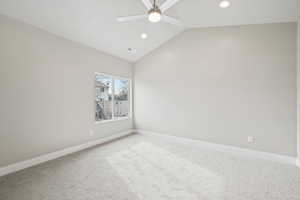 Carpeted spare room with lofted ceiling and ceiling fan