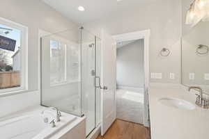 Bathroom featuring hardwood / wood-style flooring, vanity, plenty of natural light, and independent shower and bath