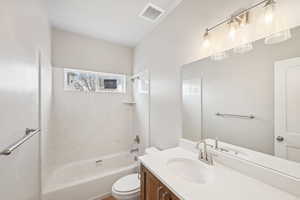 Full bathroom with vanity, toilet, and tiled shower / bath combo