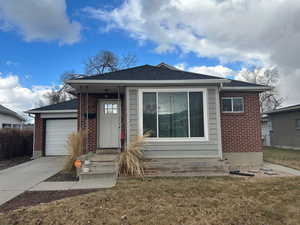 View of front facade featuring a garage and a front lawn