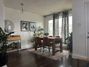 Dining room featuring dark hardwood / wood-style flooring and a textured ceiling